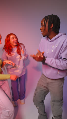 Vertical-Video-Studio-Shot-Of-Vertical-Video-Of-Group-Of-Gen-Z-Friends-Dancing-And-Having-Fun-Against-Pink-Background-3